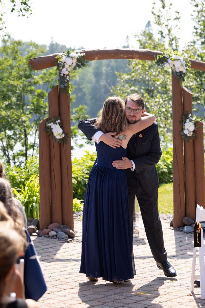 Couple embracing in a heartfelt moment at a Wisconsin wedding ceremony, captured by Beau Petersen