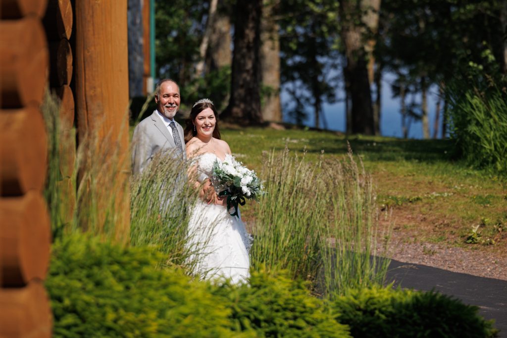 Bride and groom walking through tall grass on their wedding day in Wisconsin, captured