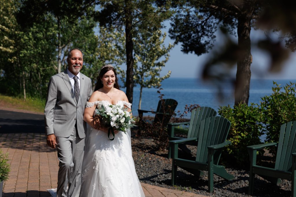 Bride walking down aisle with her father during a beautiful Wisconsin wedding ceremony near Hayward