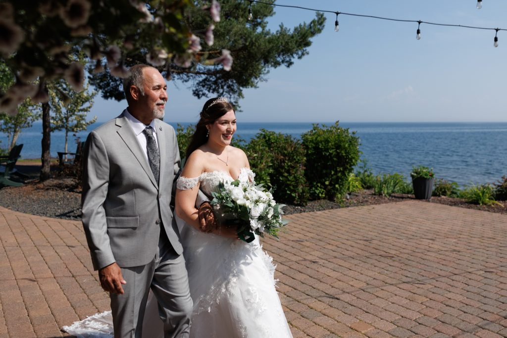 Bride and groom walking down a paved aisle during a wedding ceremony on the North