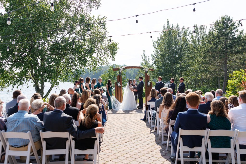 Bride and groom exchange vows during a lakeside wedding ceremony in Wisconsin, captured by Beau