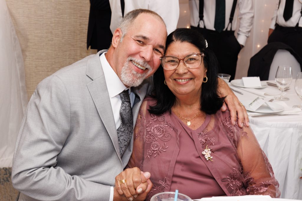 Happy couple embracing at a wedding reception, showcasing joyful moments captured by Beau Petersen Photography