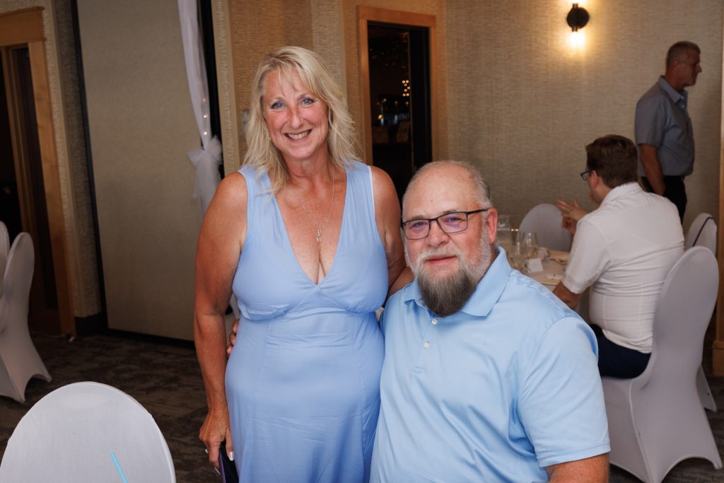 Happy wedding guests posing for a photograph at a reception in Hayward, Wisconsin, captured