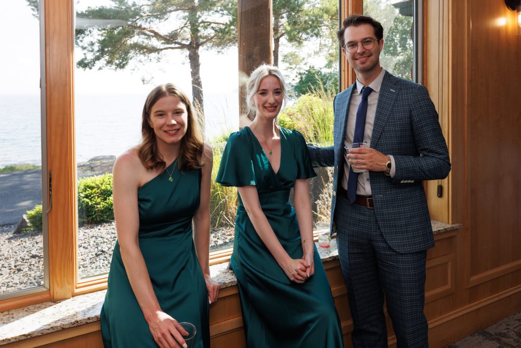 Couple and wedding party posing near a window overlooking a lake in Hayward, Wisconsin, showcasing