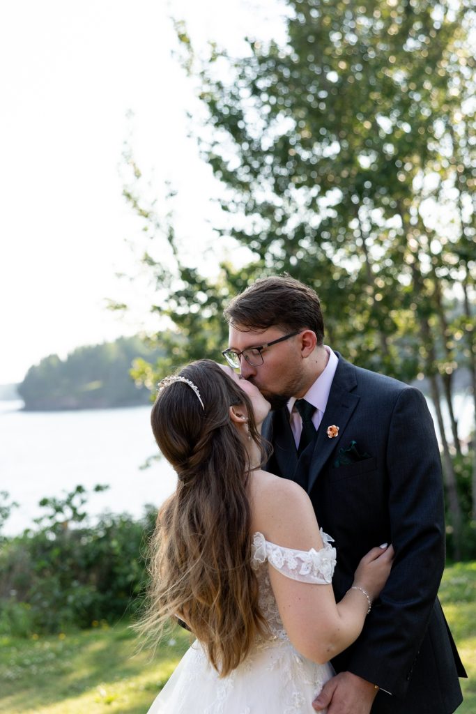 Bride and groom sharing a tender kiss during their wedding day in Hayward, Wisconsin, showcasing