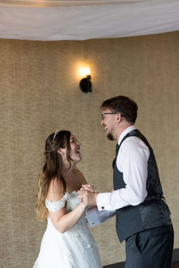 Bride and groom joyfully dancing at their wedding reception, captured by Beau Petersen Photography, showcasing