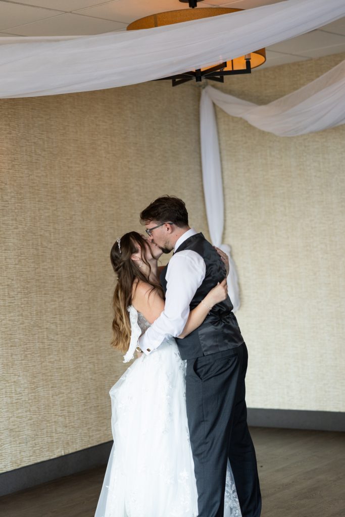 Bride and groom sharing a tender kiss during their wedding ceremony in Hayward, Wisconsin, captured