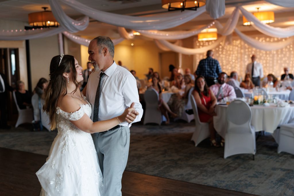 Bride and groom share a joyful first dance at their Wisconsin wedding reception, captured
