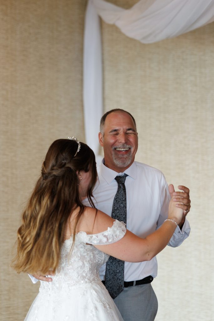 Bride and groom's father share a joyful dance at a wedding in Hayward, Wisconsin, captured