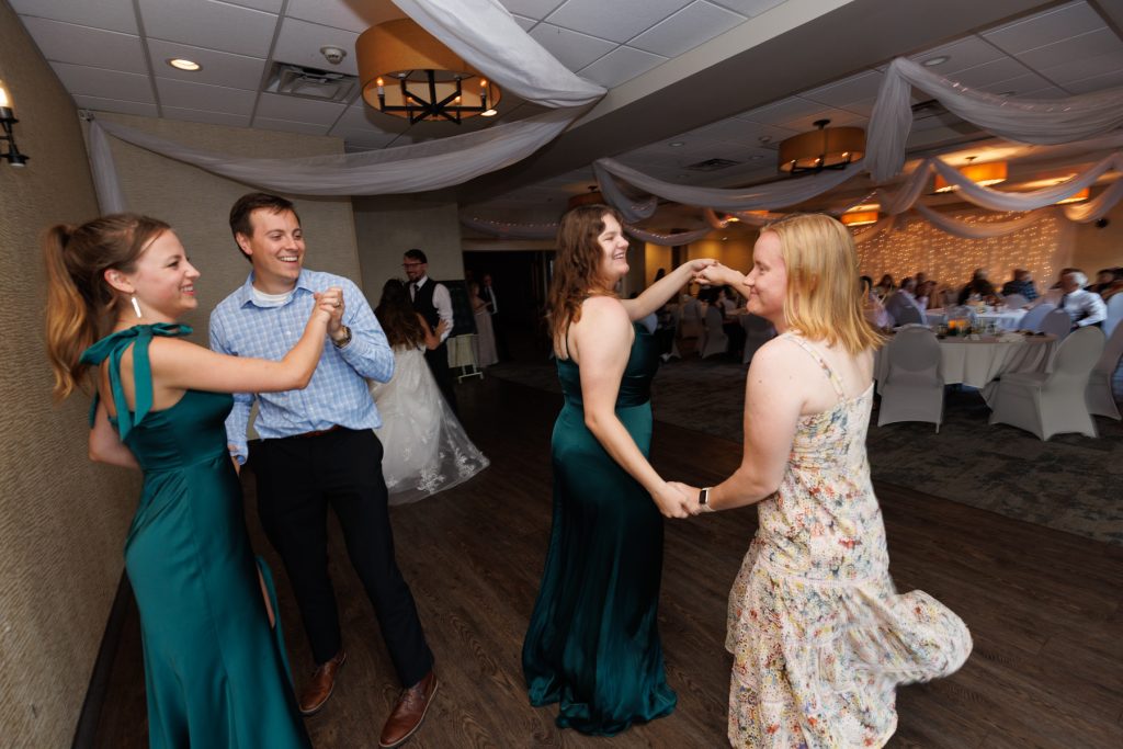 Joyful wedding guests dancing and celebrating at a reception in Hayward, Wisconsin, captured by Beau