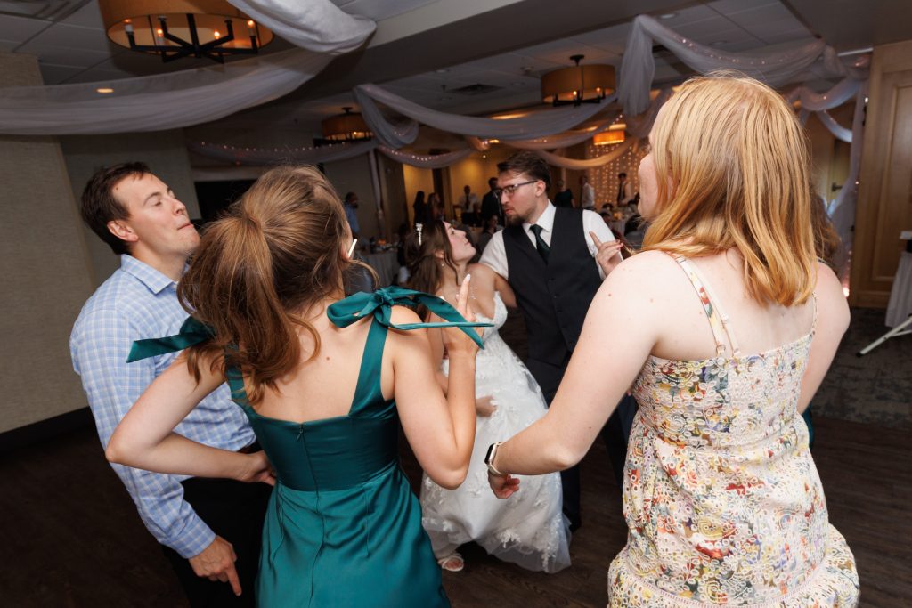 Joyful wedding guests dancing and celebrating at a reception in Hayward, Wisconsin, captured by Beau