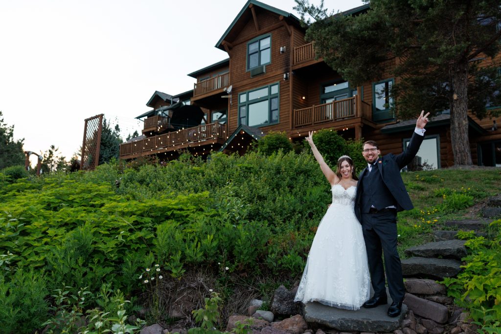 Newly married couple celebrating their wedding day in front of a beautiful lodge in Wisconsin