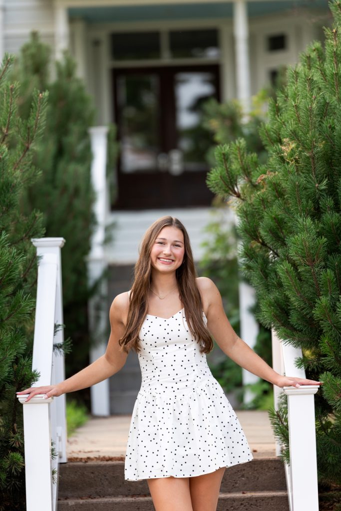 Hayward, Wisconsin high school senior Abby poses for a portrait session near a classic home