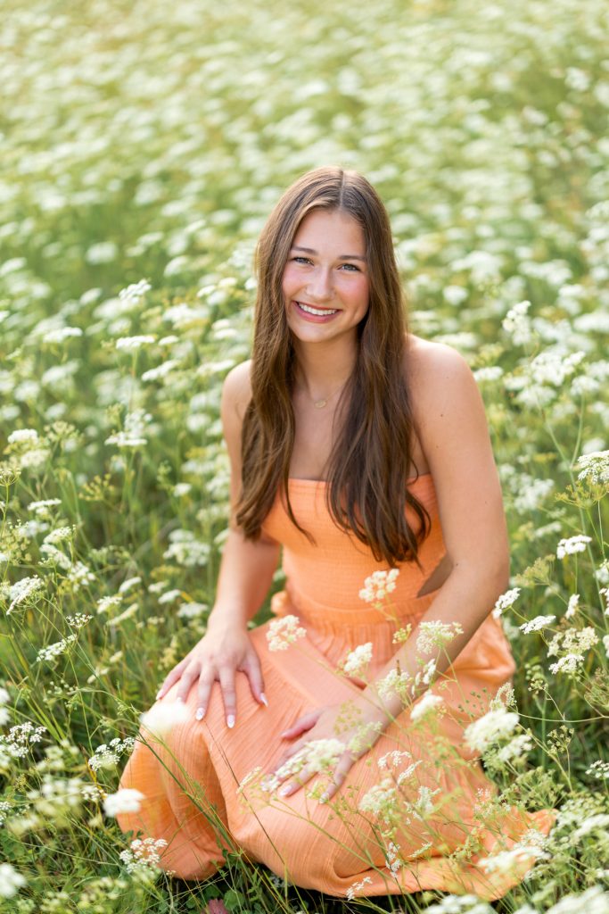 Abby, a Hayward Wisconsin High School senior, smiles warmly while posing in a field