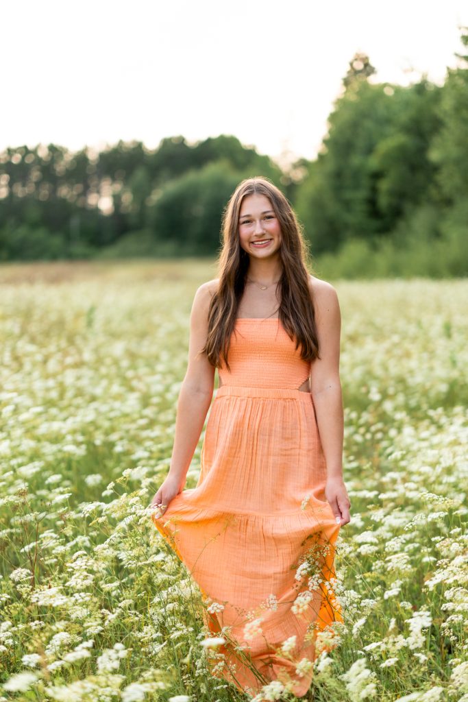 Hayward Wisconsin High School senior Abby Hayward smiles while standing in a field of white