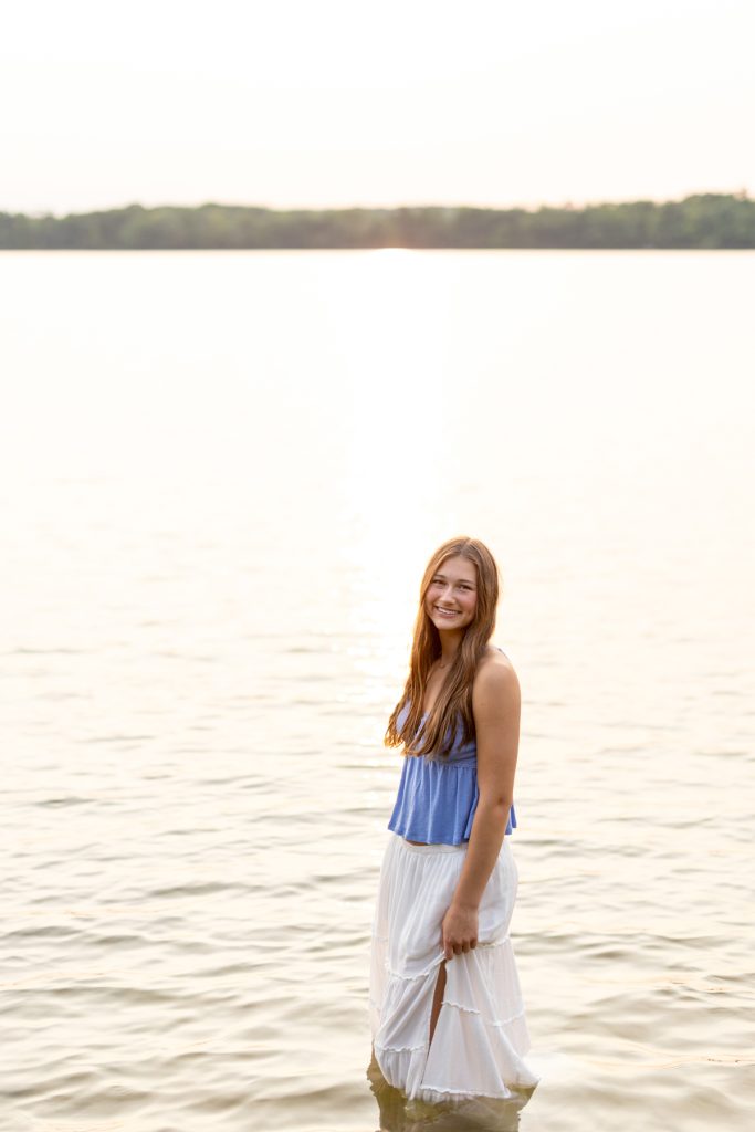 Abby, a Hayward Wisconsin High School graduate, smiles while standing in shallow water