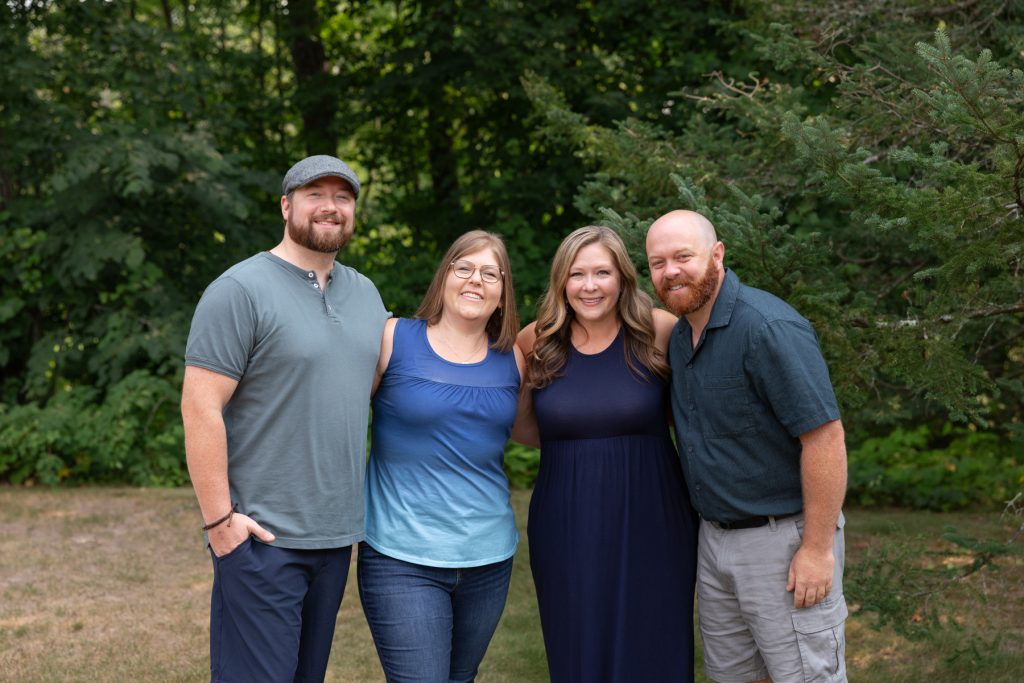 A family of four smiles for a portrait session, capturing cherished memories of family time