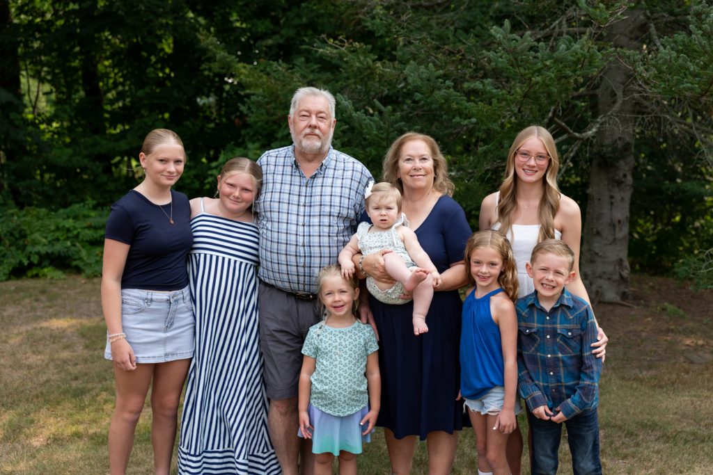 Large multigenerational family portrait captured by Superior Sunset Studio, showcasing a joyful moment of family