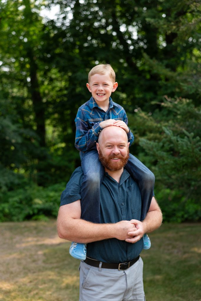 A father and son share a joyful moment during a family portrait session, capturing cherished