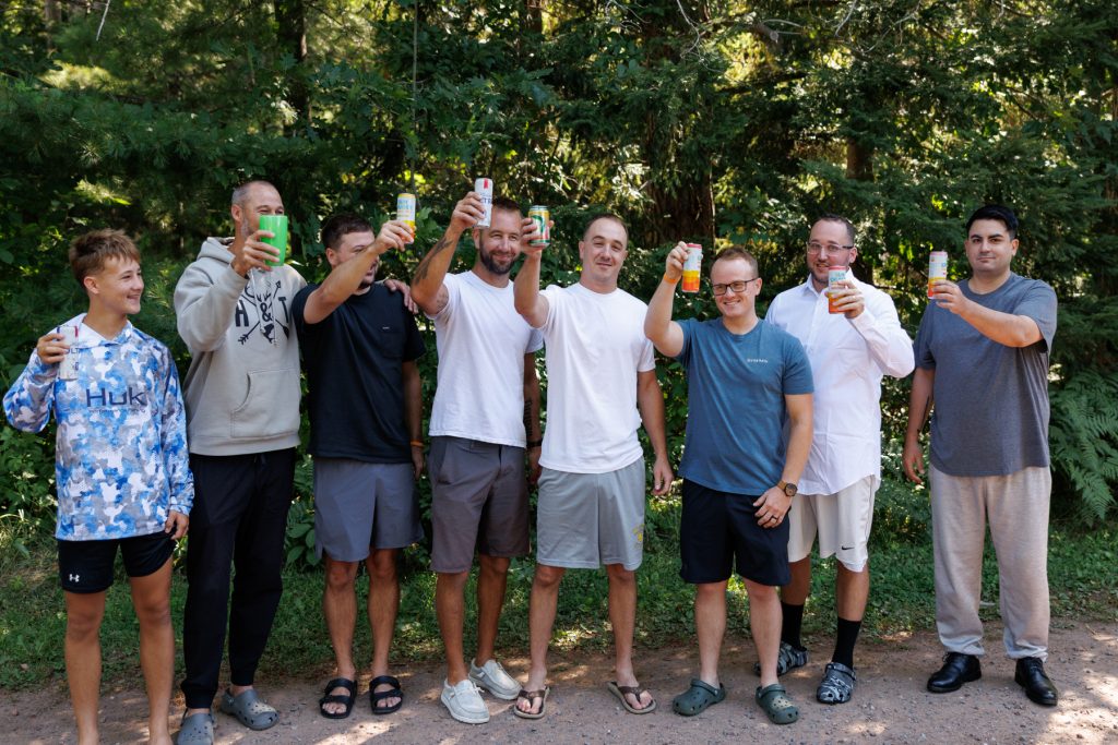 Group of groomsmen and a young boy toasting with drinks at a Lakewoods Resort wedding