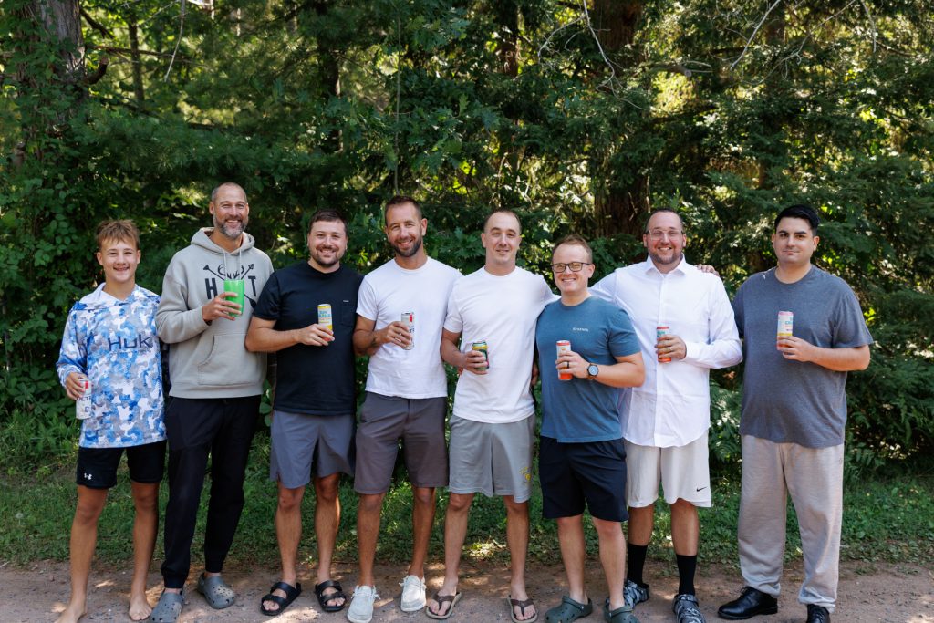 Group of men gathered outdoors at a Lakewoods Resort wedding in Cable, Wisconsin, enjoying drinks