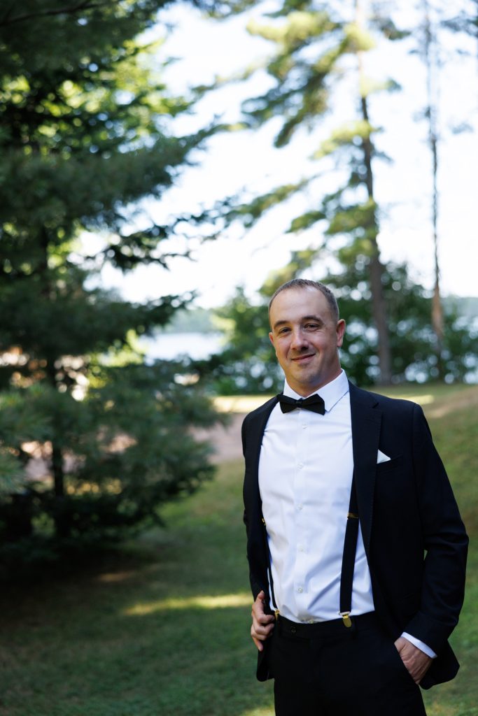 Groom in a tuxedo and bow tie smiles for the camera during a Lakewoods Resort