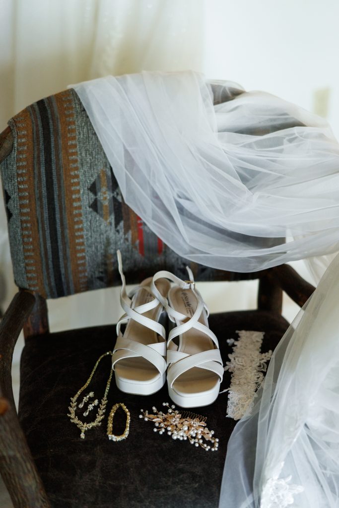 White wedding shoes and delicate veil resting on a chair, showcasing details from Bianca