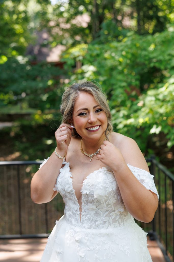 Bride Bianca smiling and adjusting her earrings while getting ready for her Lakewoods Resort wedding