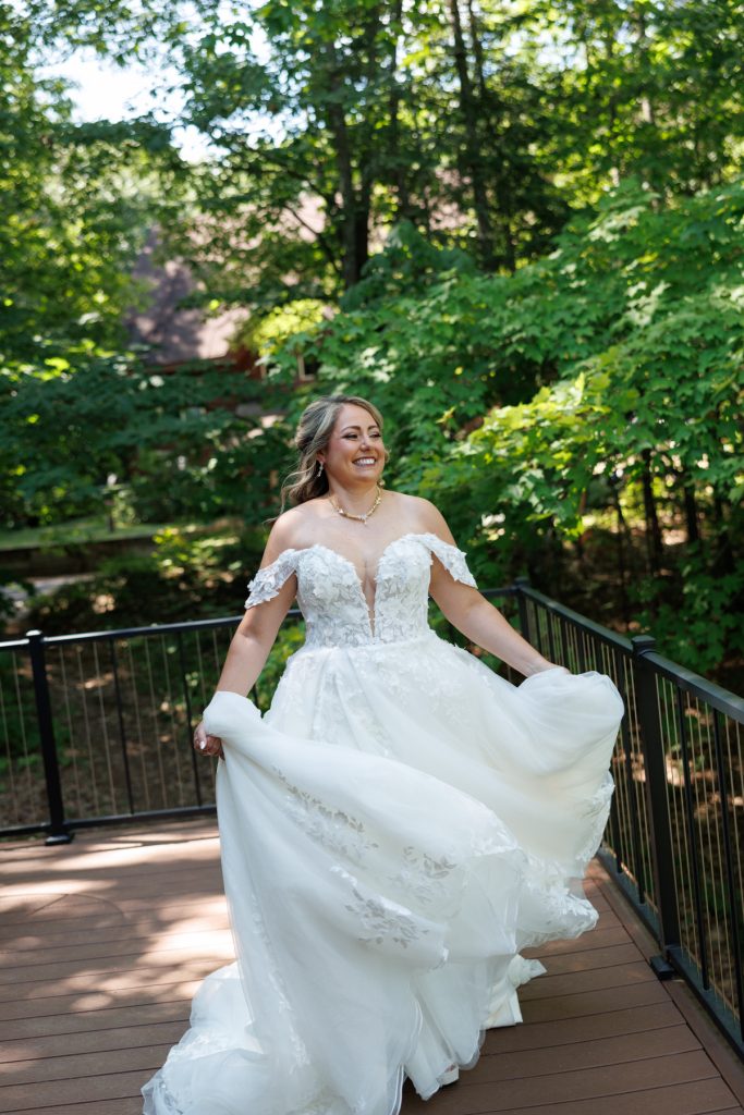 Bride Bianca joyfully twirls in her off-the-shoulder wedding gown at Lakewoods Resort in Cable, Wisconsin