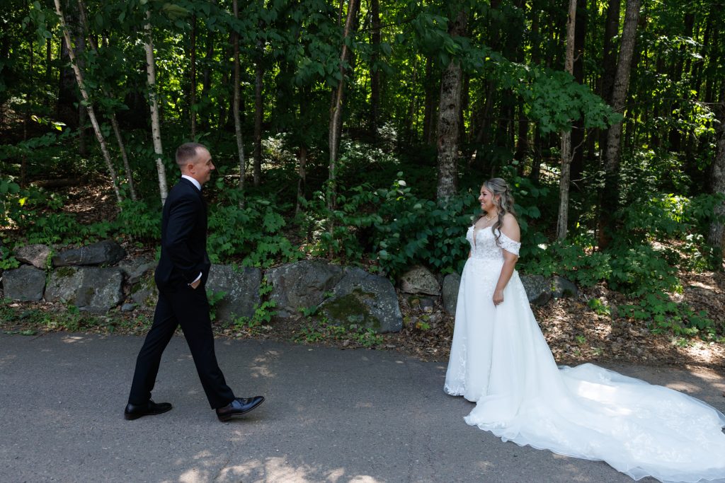 Bianca and Nick share a first look moment amidst the lush greenery at Lakewoods Resort