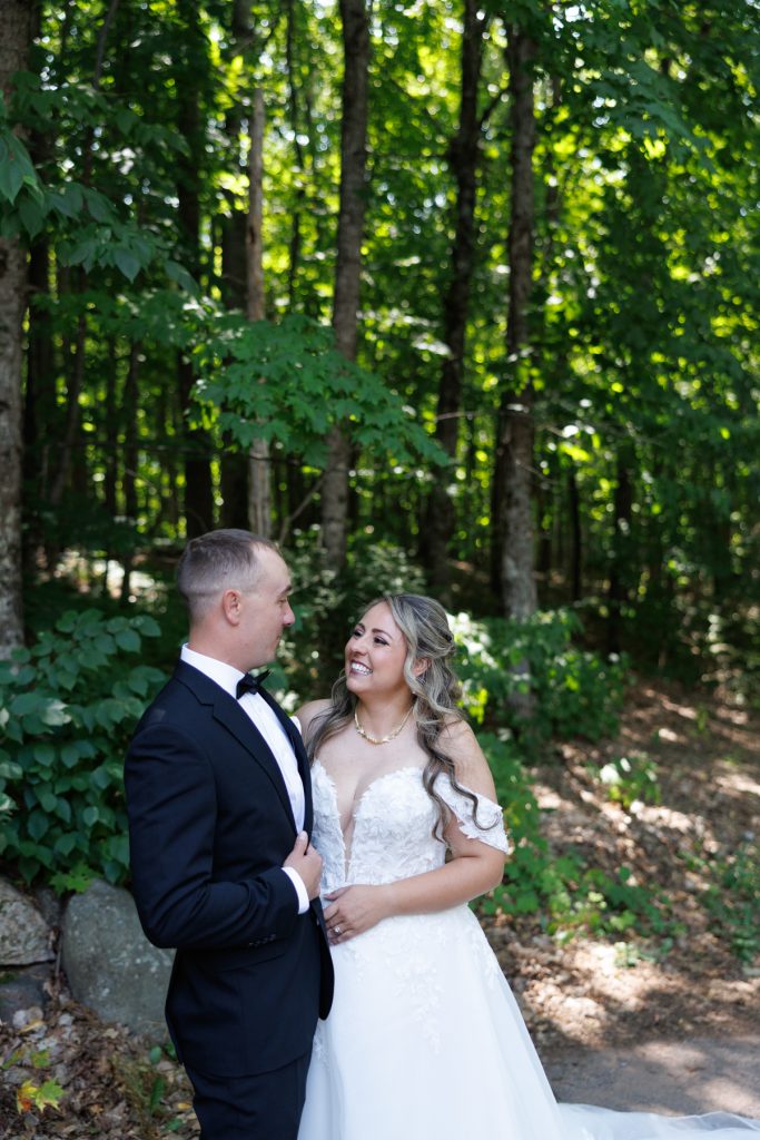 Bride and groom share a joyful moment in a wooded setting at a Lakewoods Resort