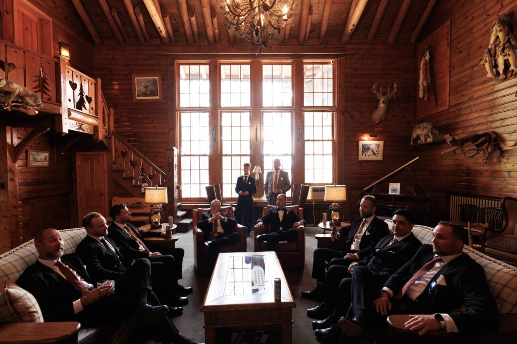 Groom and groomsmen gathered in a rustic, wood-paneled room at Lakewoods Resort in Cable, Wisconsin