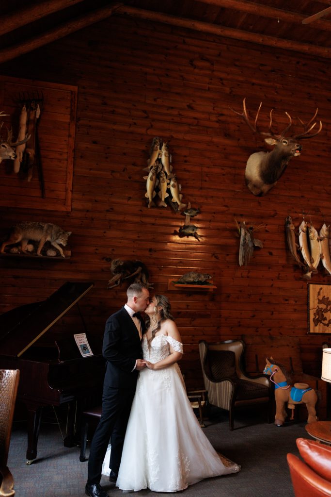 Bianca and Nick, the wedding couple, share a tender moment embraced in the rustic interior