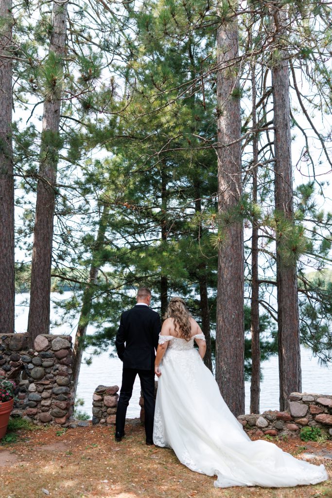 Bianca and Nick, the happy couple, stand facing a lake at their Lakewoods Resort wedding