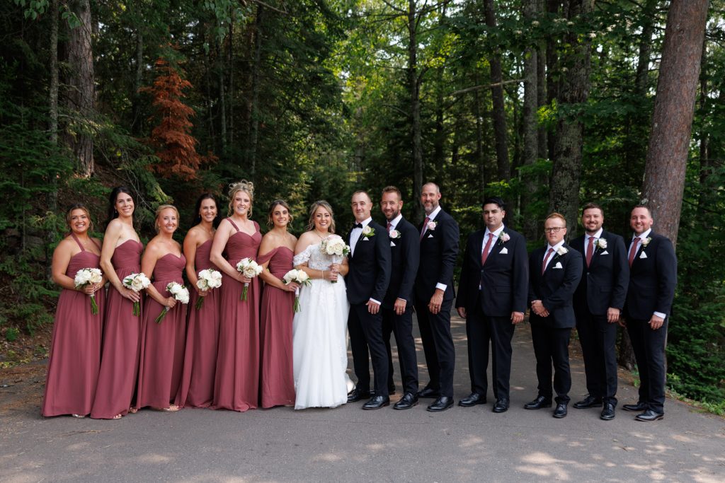 Bianca and Nick's wedding party poses outdoors at Lakewoods Resort in Cable, Wisconsin, captured