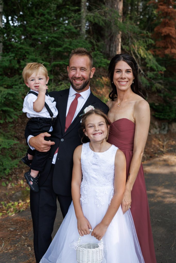 Bianca and Nick, along with their family, pose for a portrait during their destination wedding