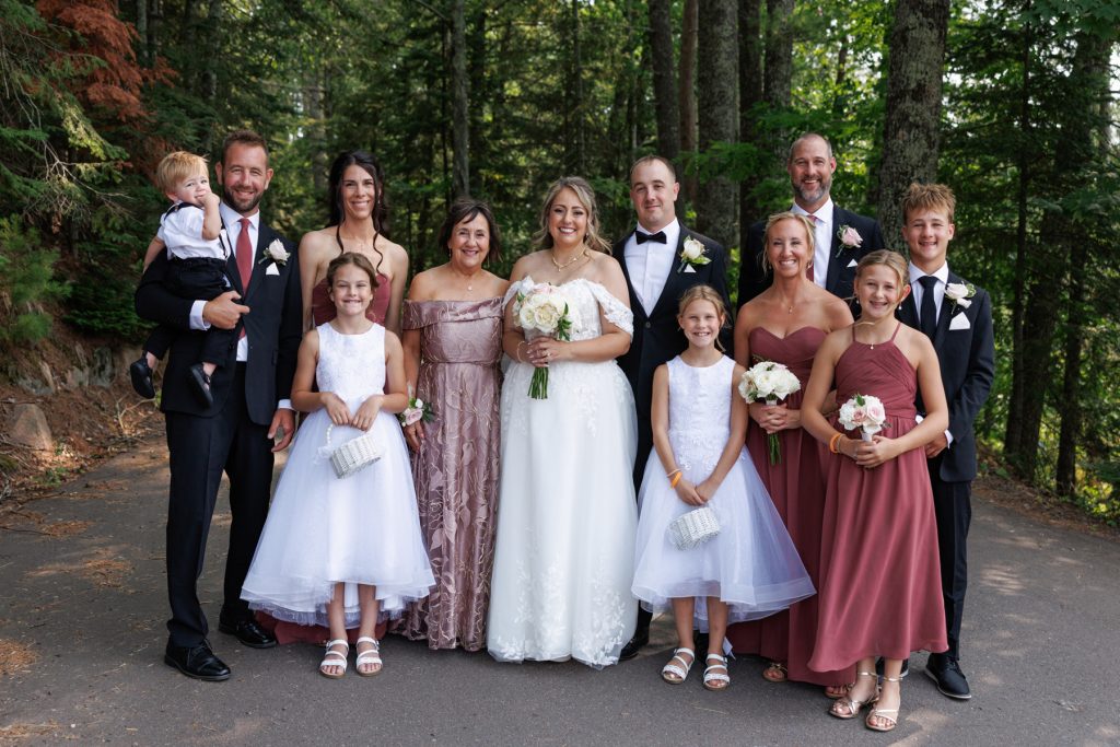 Bianca and Nick’s wedding party poses for a group photograph at Lakewoods Resort in Cable