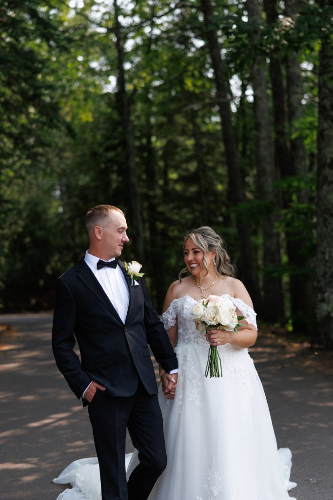 Bianca and Nick, the Lakewoods Resort wedding couple, share a joyful moment walking hand-in-hand amidst