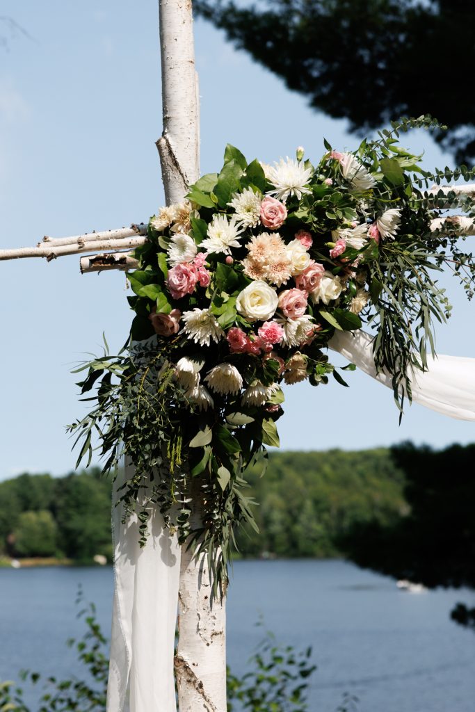 Elaborate floral arch decorated with roses and greenery, featured at a Lakewoods Resort wedding