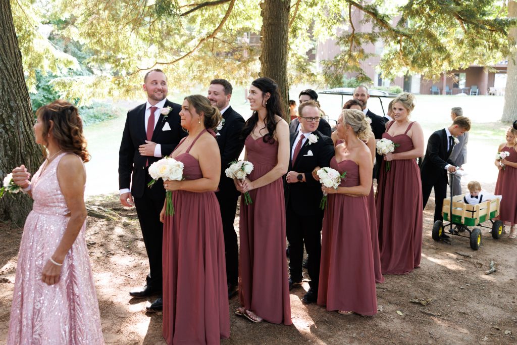 Wedding party, including bridesmaids and groomsmen, posing together outdoors at Lakewoods Resort in Cable, Wisconsin