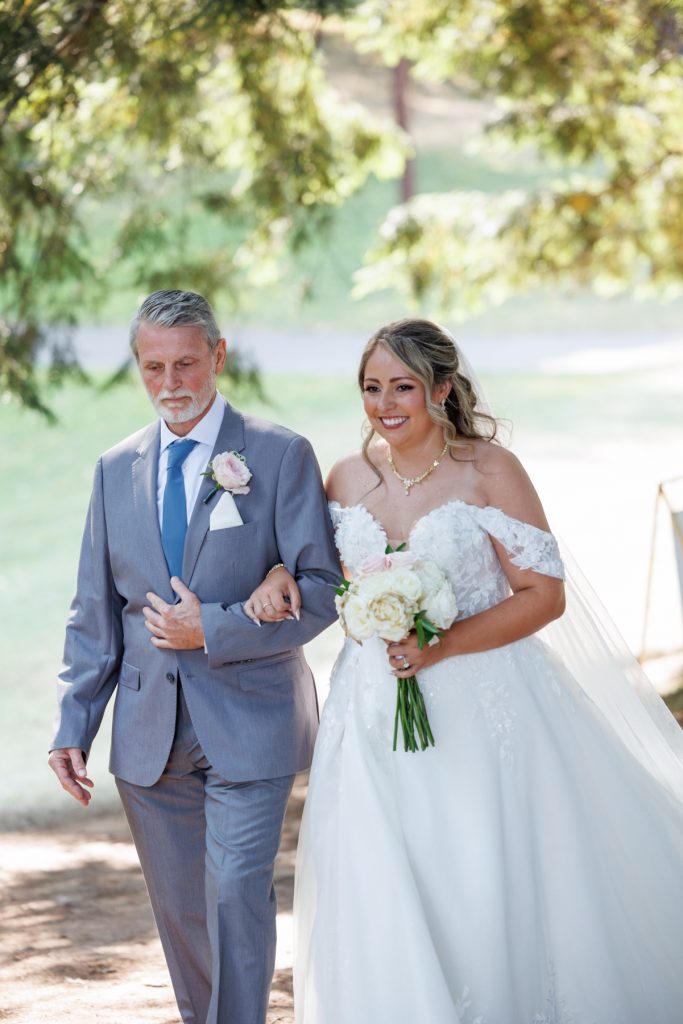 Bride walking down the aisle with her father at a Lakewoods Resort wedding in Cable