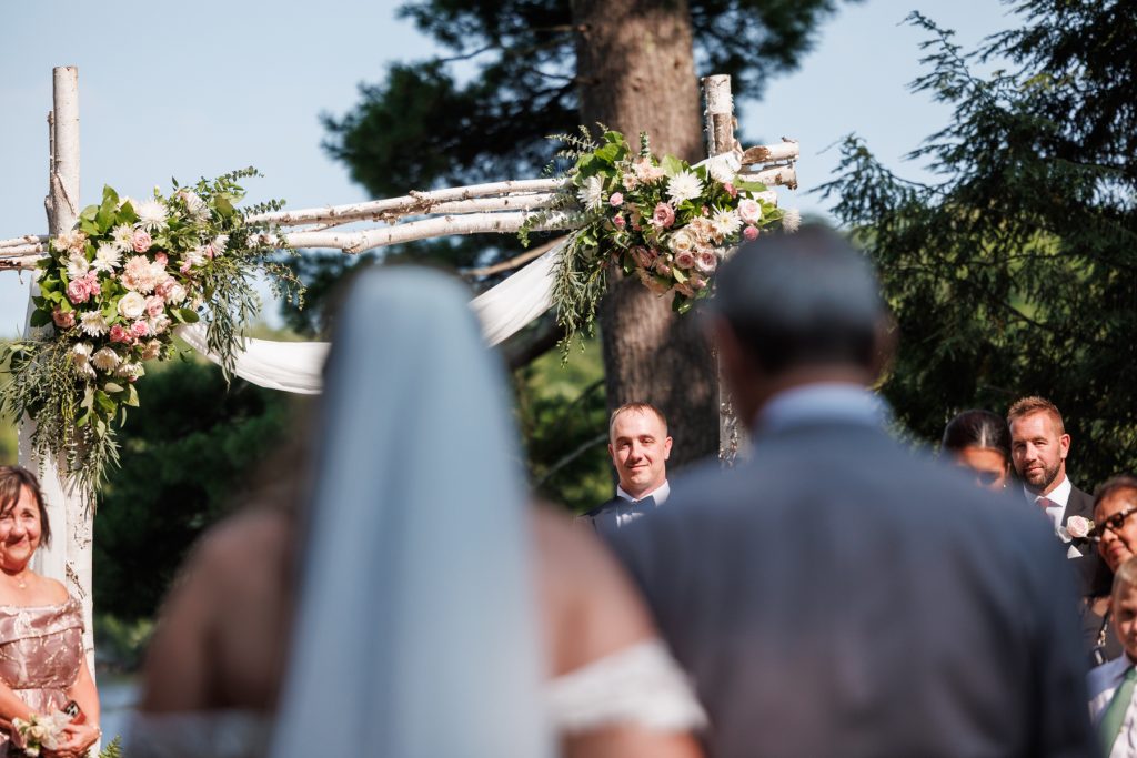 Bride in veil walking toward groom at Lakewoods Resort wedding ceremony, captured by Beau Petersen