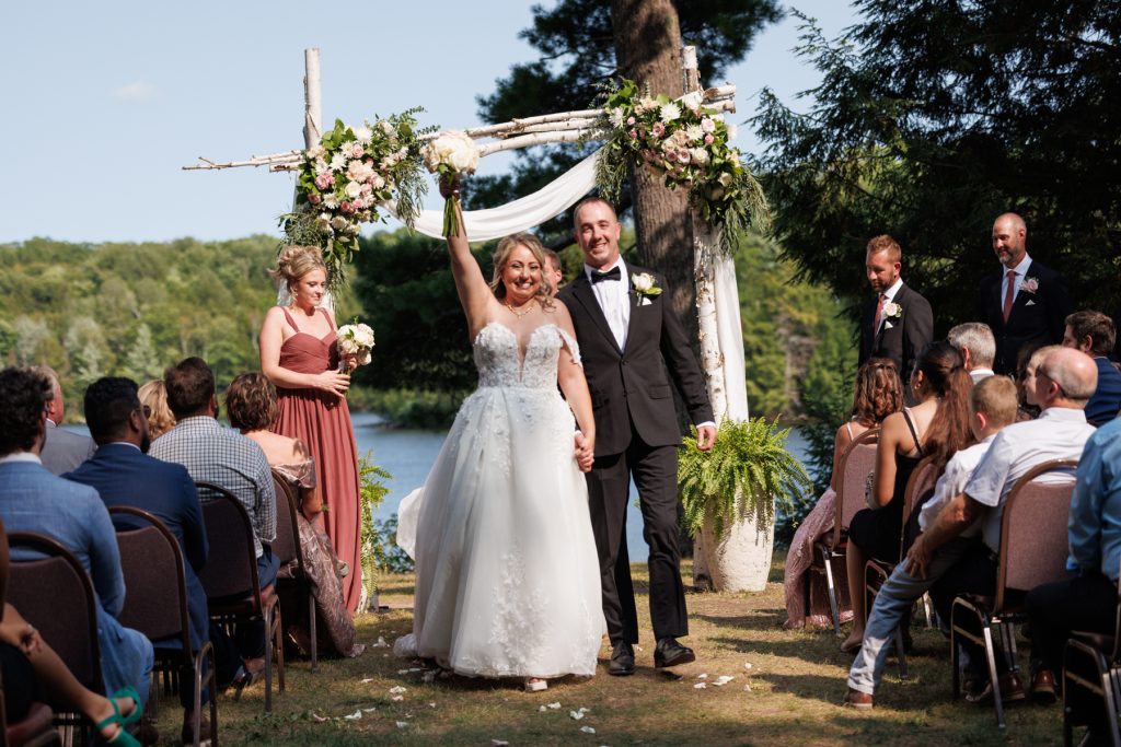 Bianca and Nick, the newly married couple, joyfully raise their hands during their destination wedding