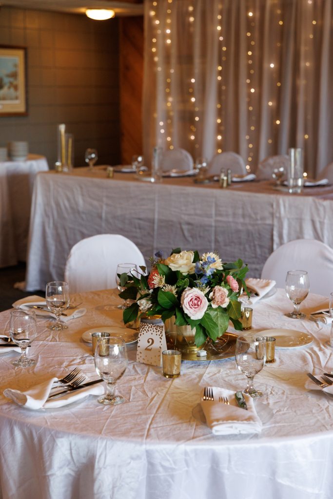 Elegant wedding reception table setting at Lakewoods Resort in Cable, Wisconsin, featuring a floral centerpiece