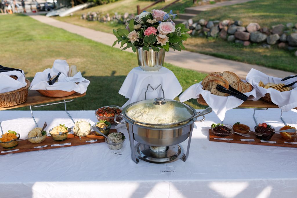 Elegant wedding reception buffet display with floral arrangements and various appetizers at Lakewoods Resort