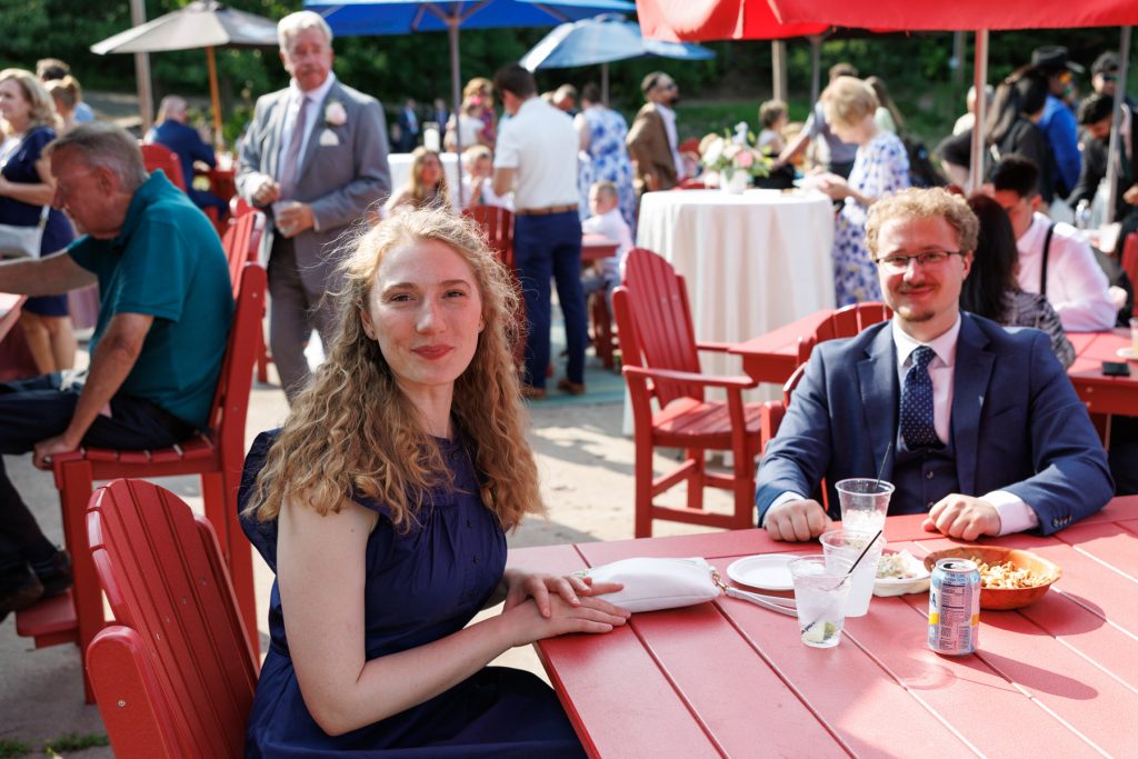 Bianca and Nick, the wedding couple, smiling and seated at a red table