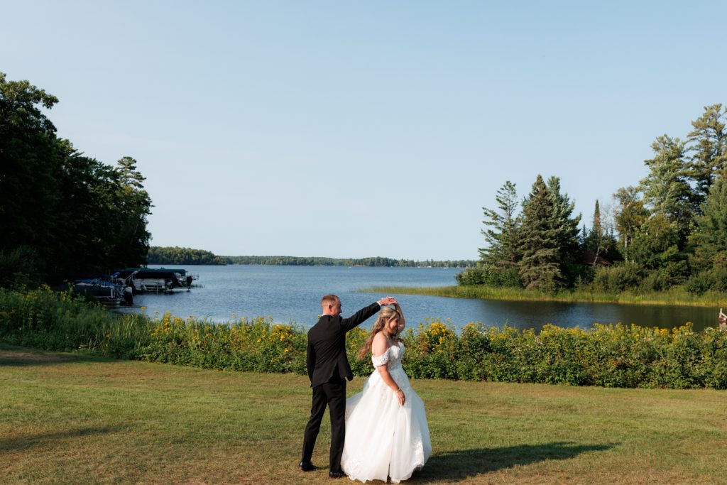 Bianca and Nick, the happy couple, dance joyfully on the lawn at Lakewoods Resort
