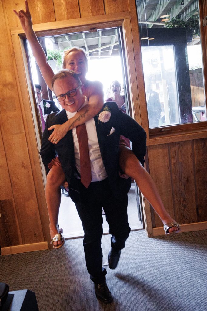 Bride and groom playfully celebrate at Lakewoods Resort wedding in Cable, Wisconsin, with the groom