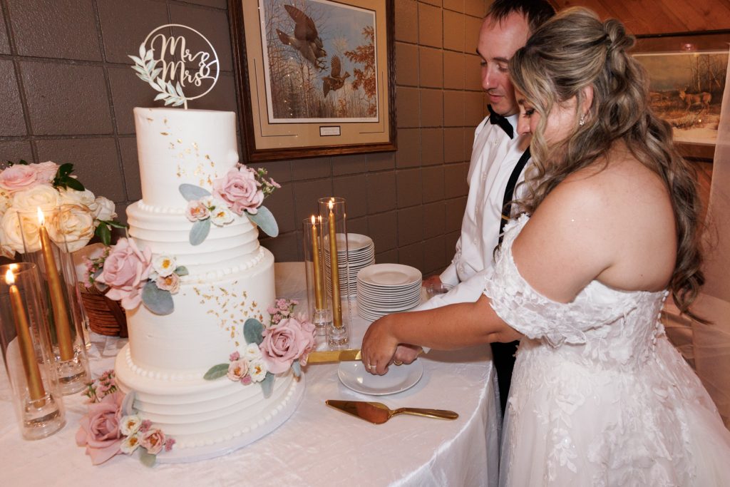 Bianca and Nick, the newlyweds, cut their tiered wedding cake at Lakewoods Resort in Cable