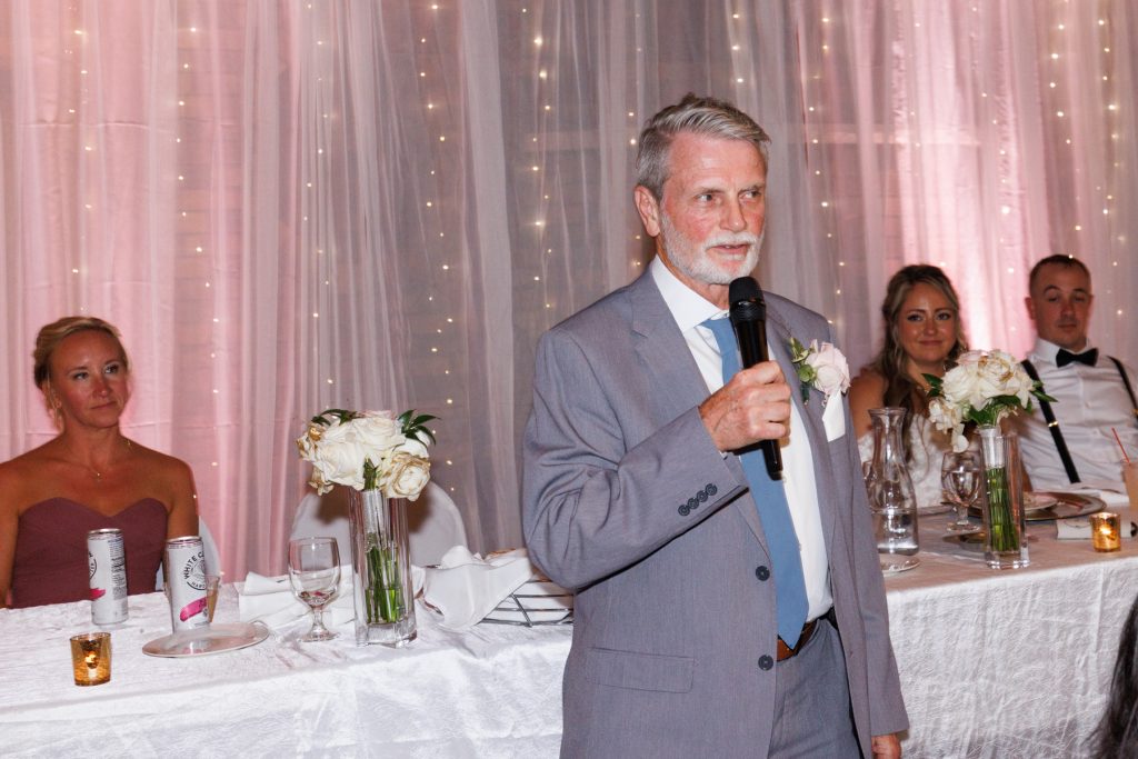 Man speaking into microphone at a wedding reception at Lakewoods Resort in Cable, Wisconsin, captured